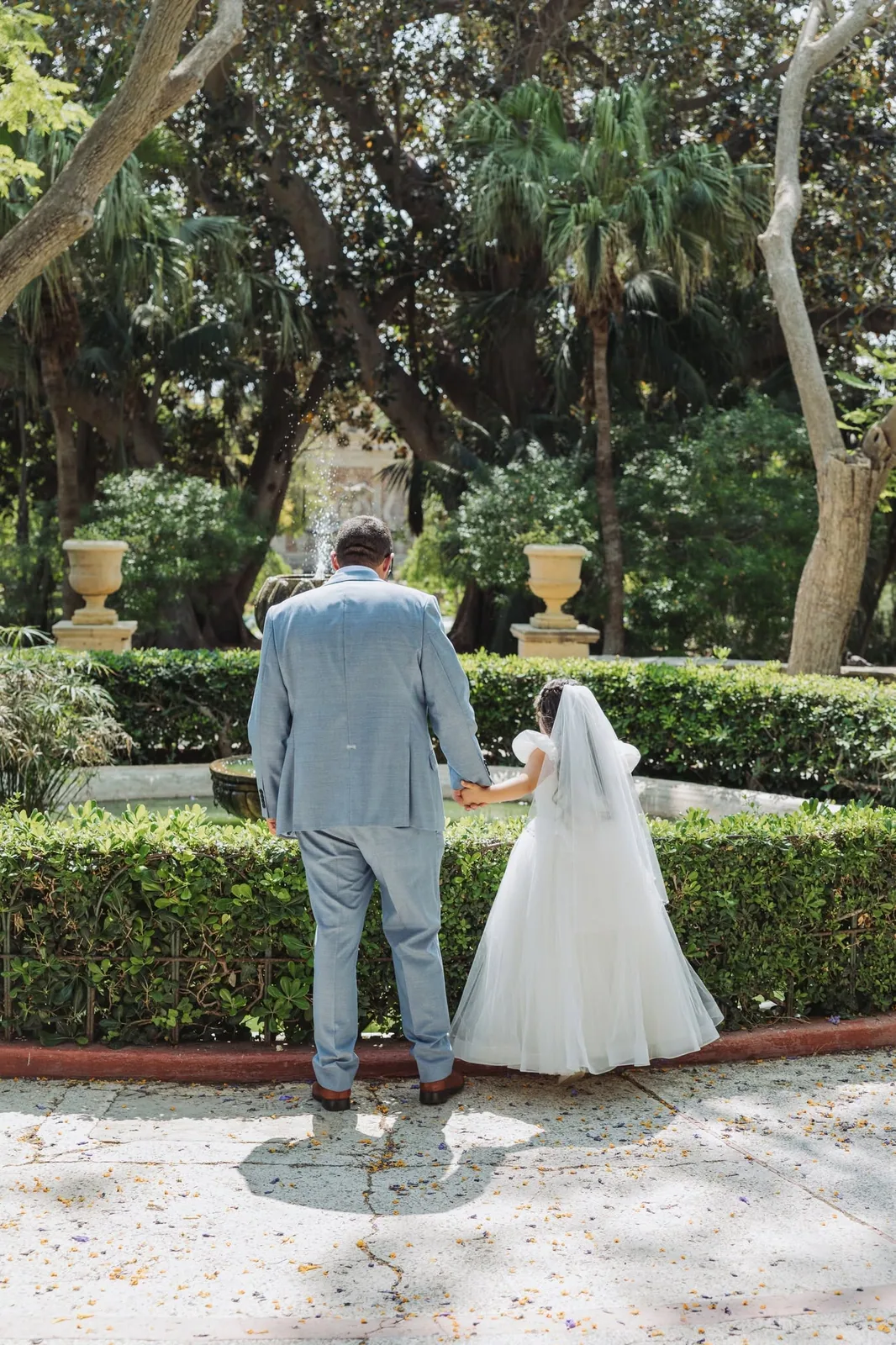 father and communion girl walking in garden malta