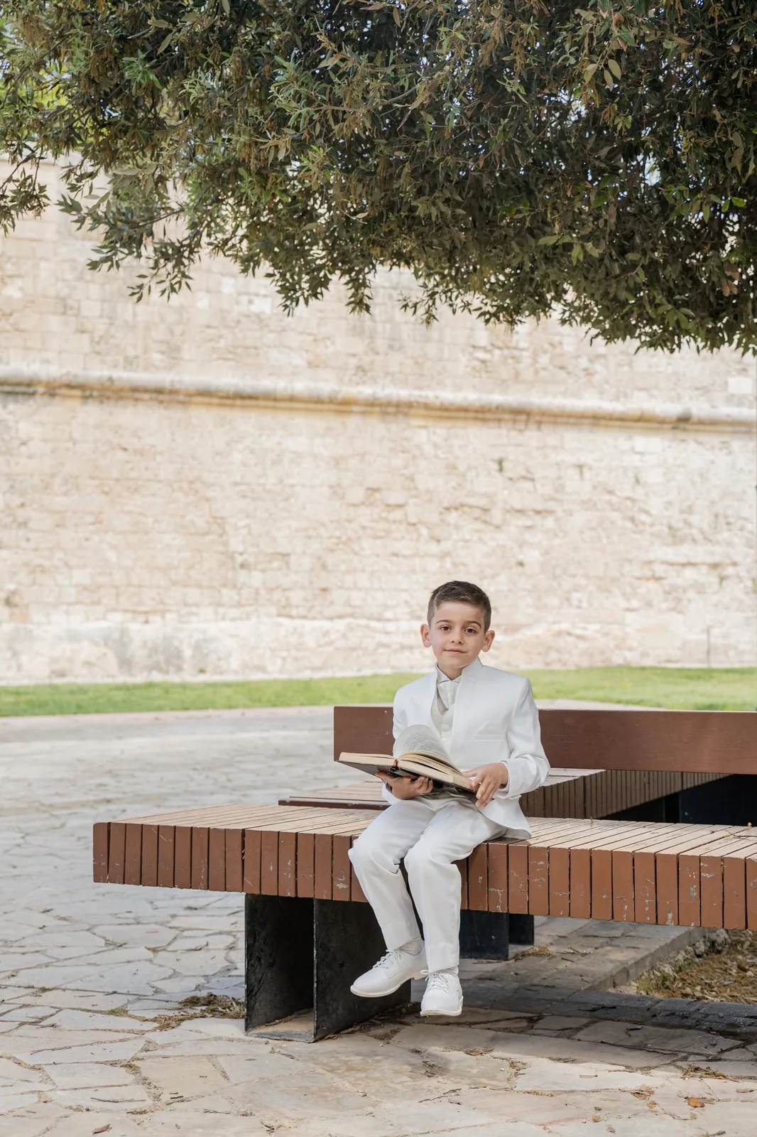 first communion boy reading on bench malta