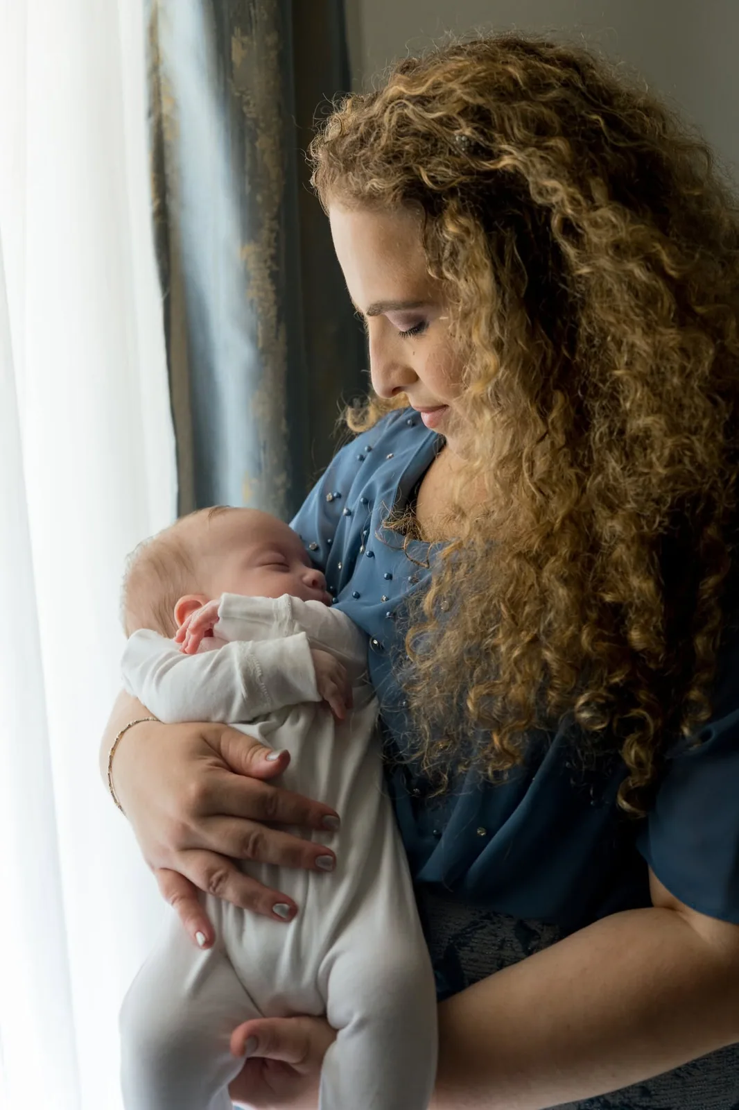 mother cradling baby in blue dress malta
