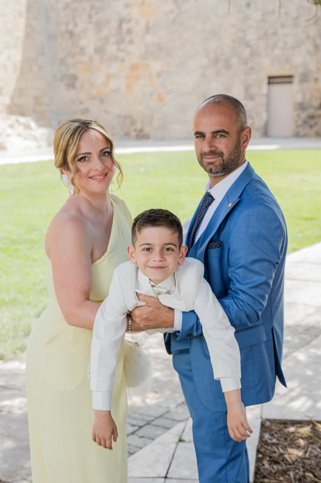 parents embracing son on communion day malta