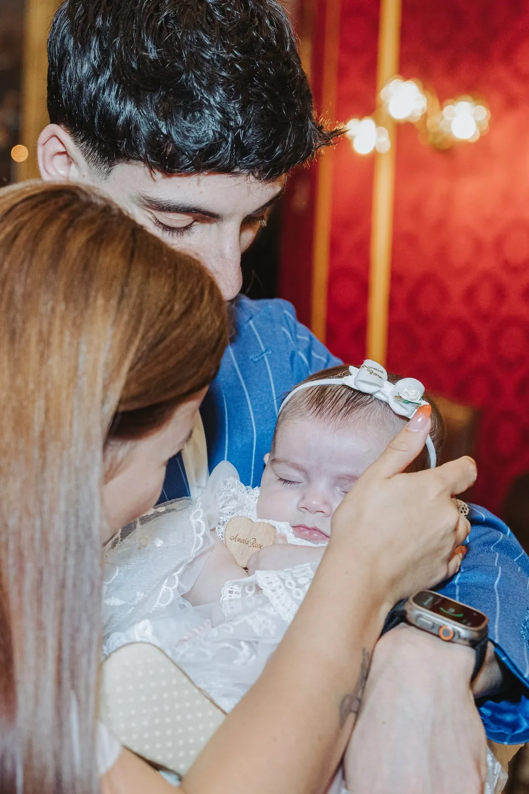 parents kissing baby during christening malta