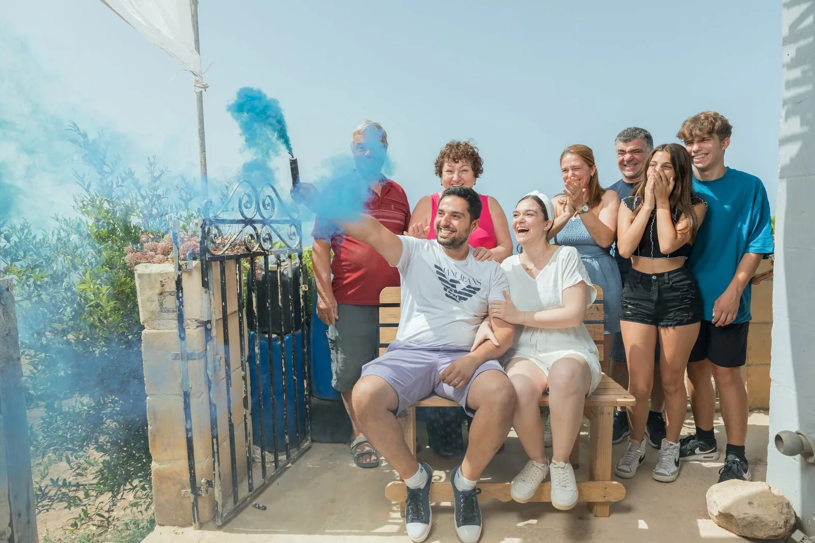 family celebrating with blue smoke at gender reveal malta