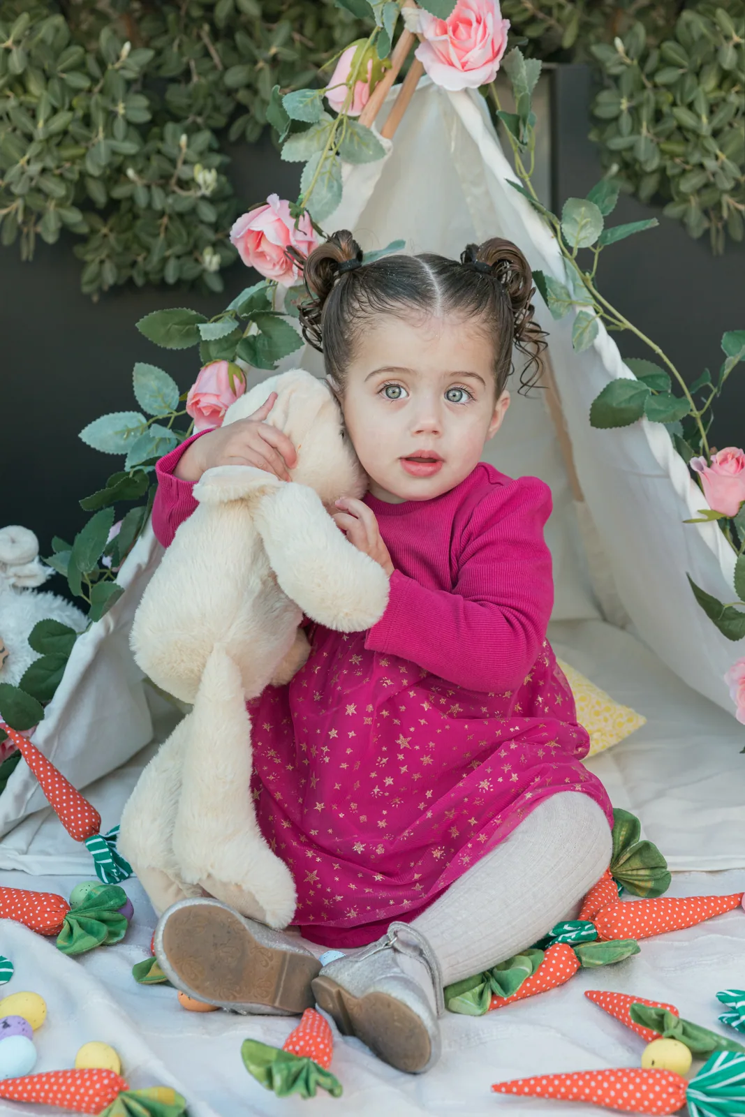girl holding teddy bear at floral teepee malta