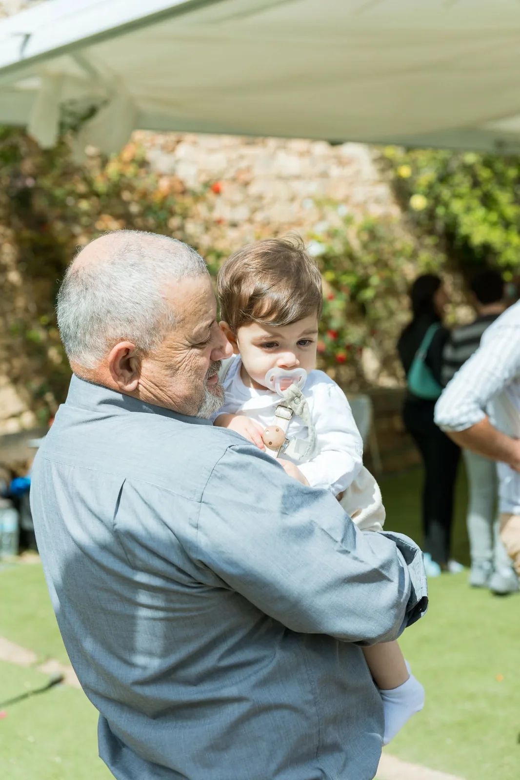 grandfather holding toddler at garden party malta