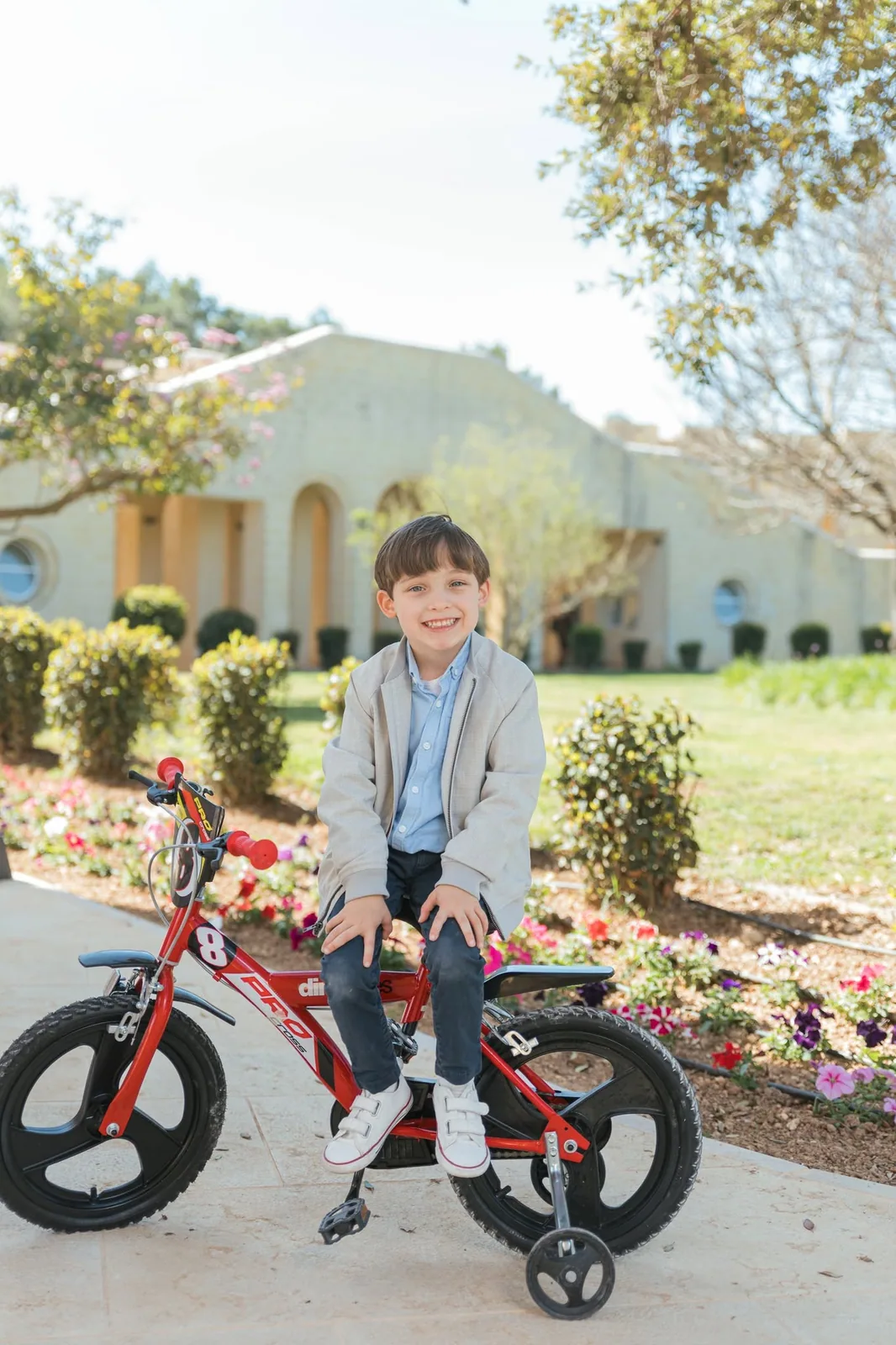 boy with red bicycle in garden malta