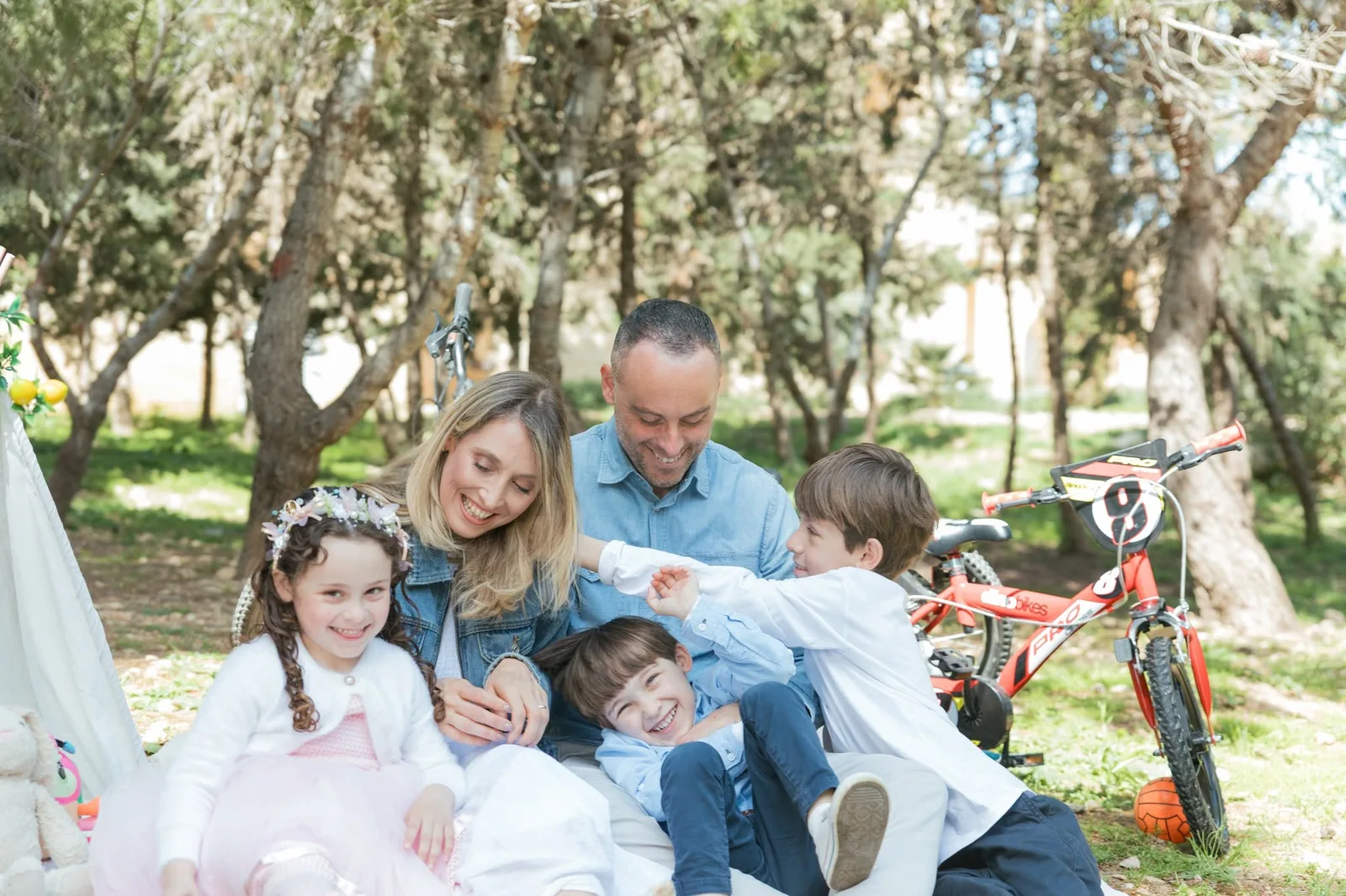 family cuddling on woodland picnic blanket malta