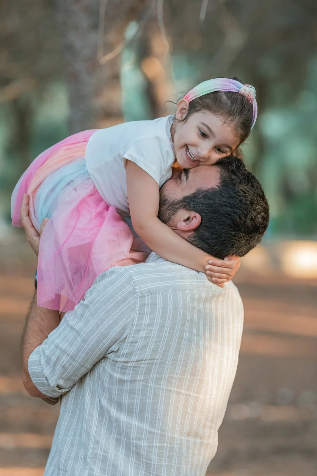father lifting daughter in pink skirt malta