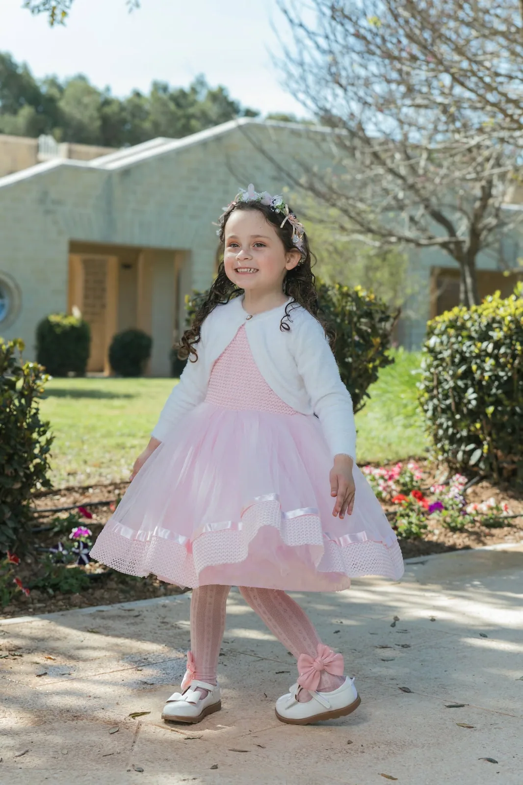 girl twirling in pink dress on garden path malta