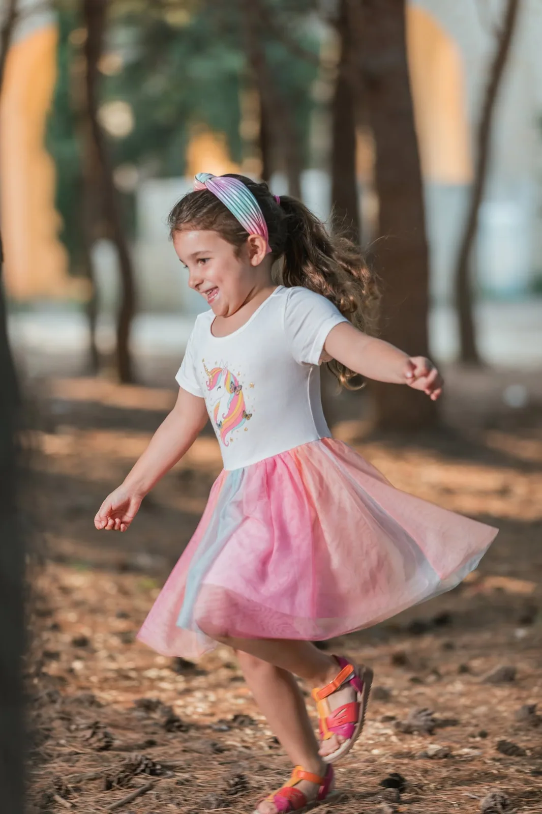girl twirling in rainbow skirt in woodland malta