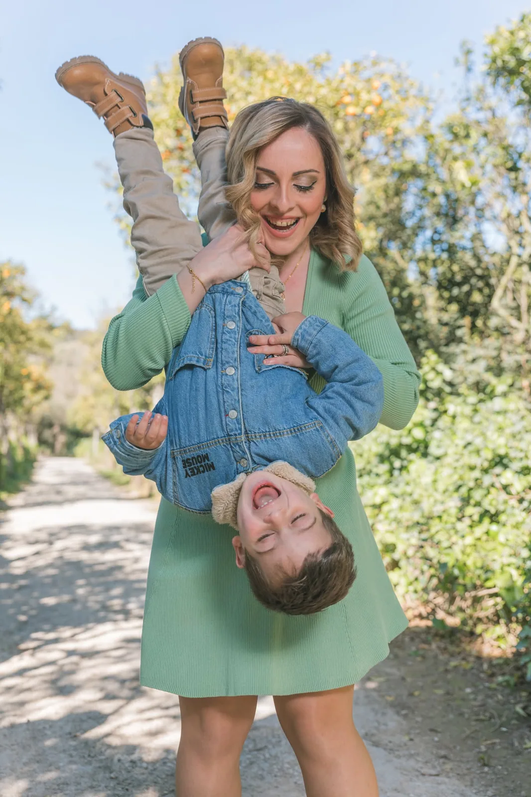 mother holding playful son upside down malta