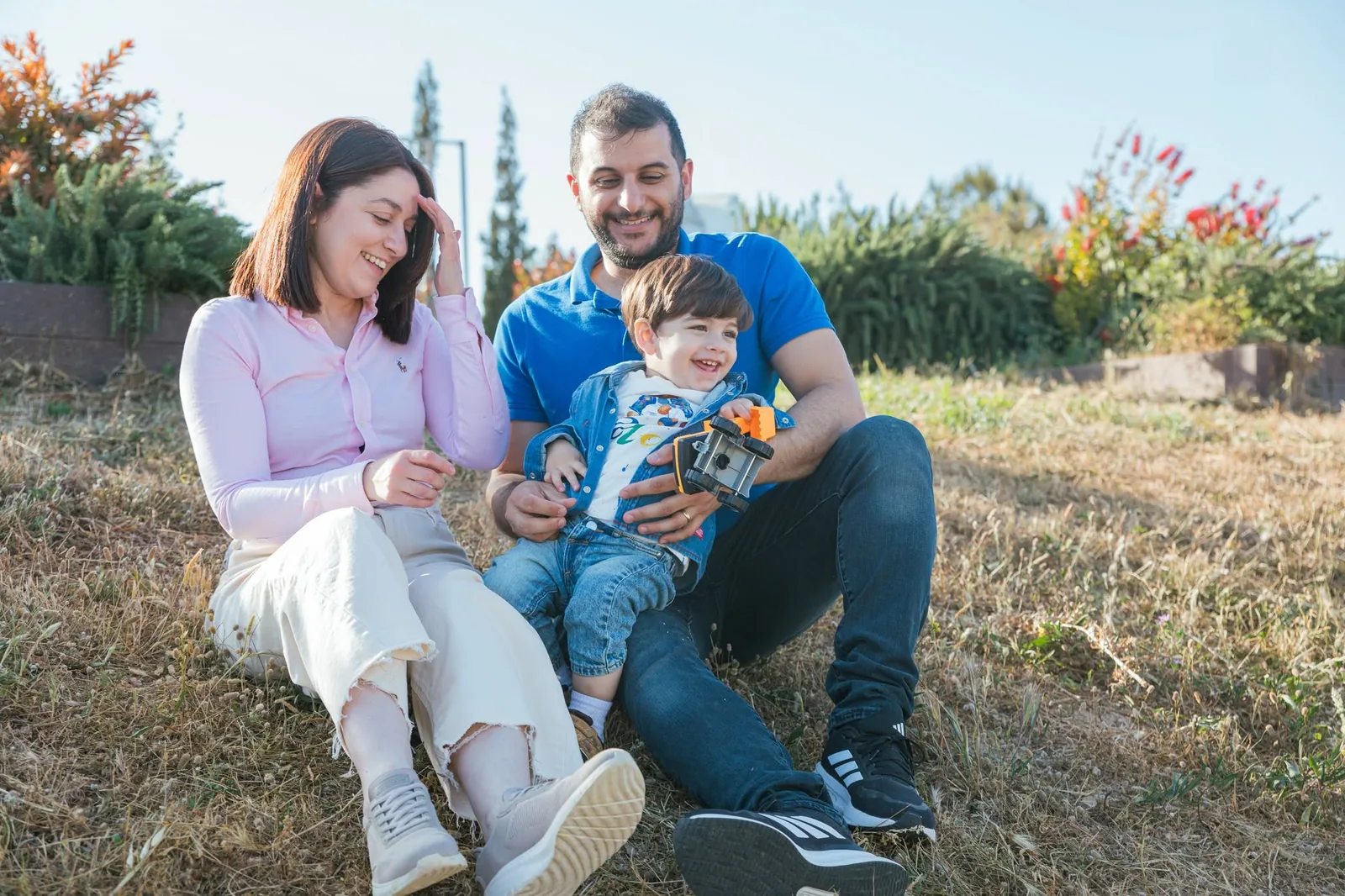 parents and toddler seated outdoors malta