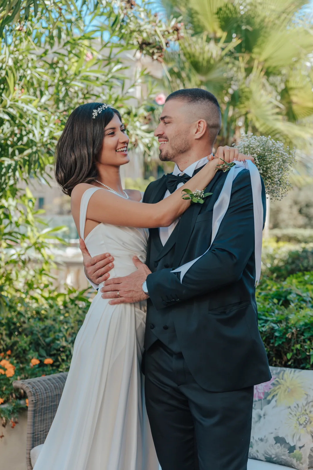 A bride and groom embracing beneath a tree in a Maltese garden