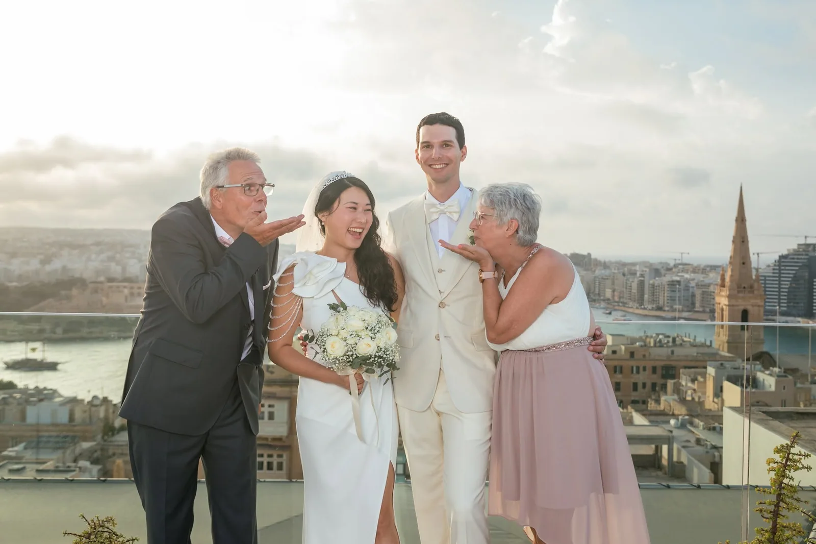 bride and groom with family on rooftop malta
