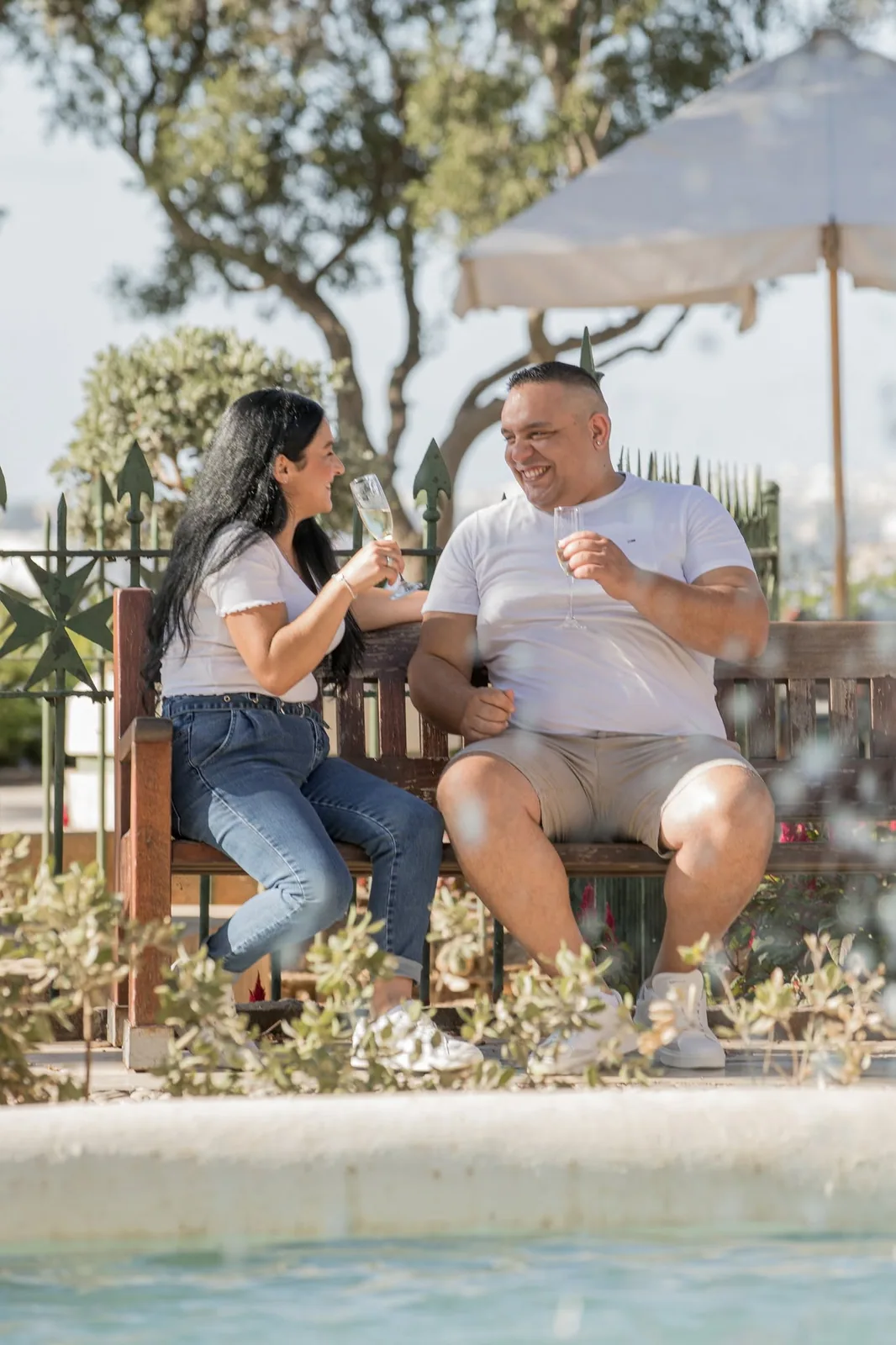 couple sharing drinks on garden bench malta