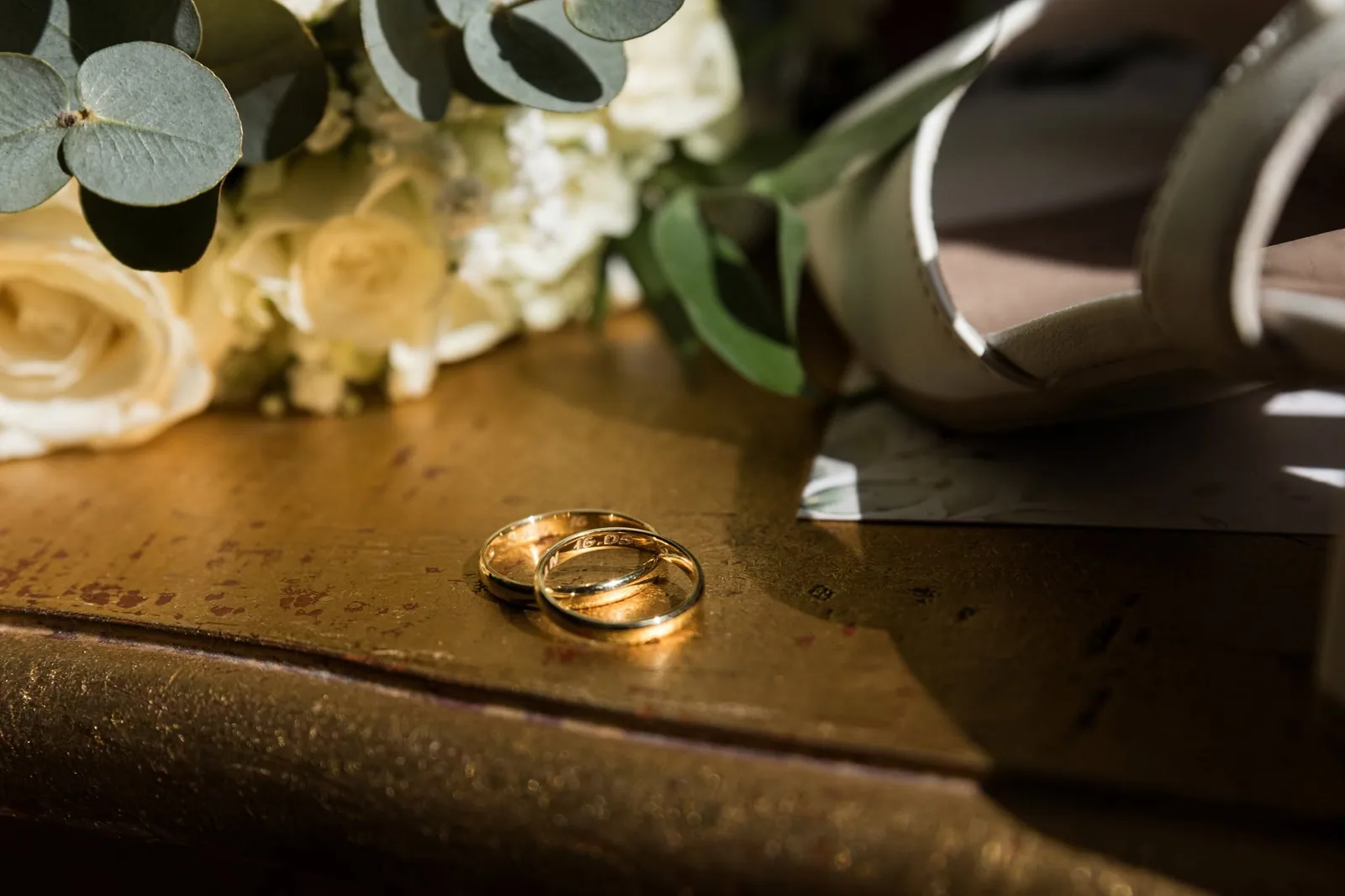 gold wedding rings beside bridal bouquet malta