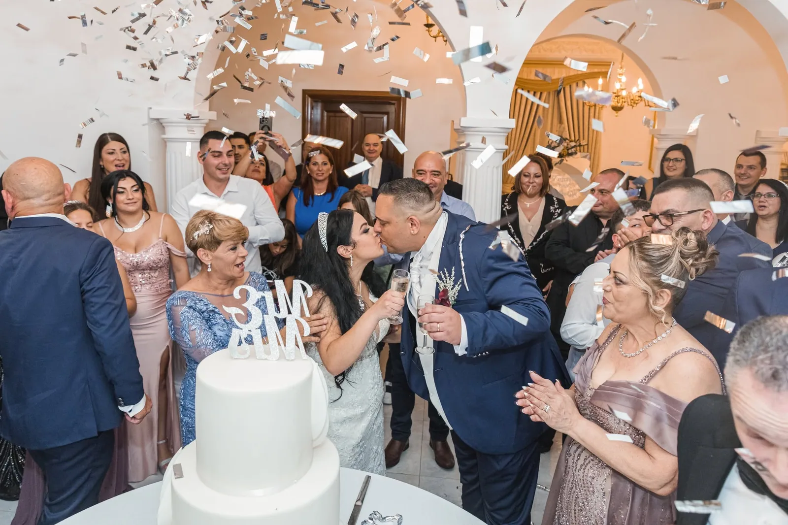 newlyweds cutting cake under confetti malta