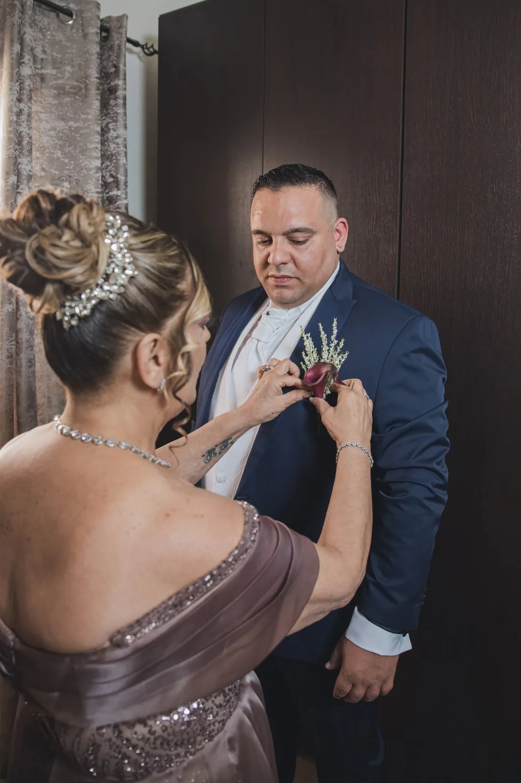 woman pinning grooms boutonniere malta